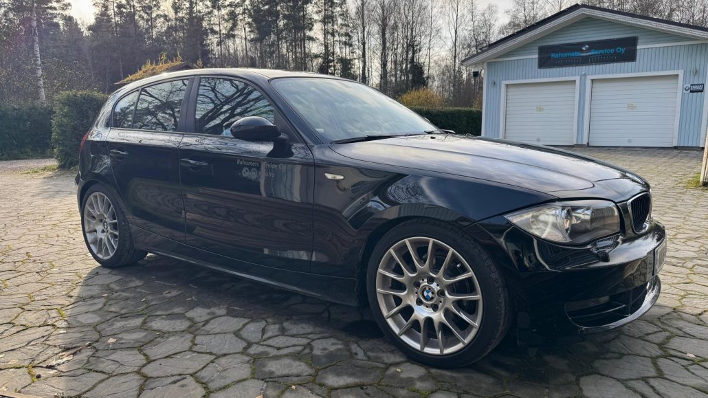 Rahumets Servicen huollon sijaisauto, musta BMW 116i, korjaamon edessä Tuusulassa